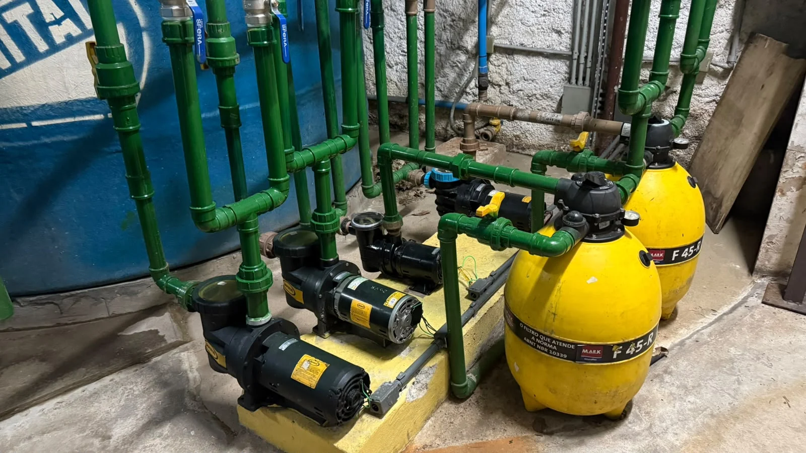 Bombas e filtros instalados em uma sala técnica de piscina